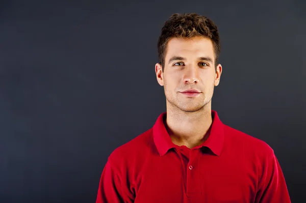 Hombre sobre fondo negro en camisa roja con sonrisa — Foto de Stock