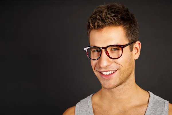 Hombre guapo en camiseta gris con sonrisa — Foto de Stock