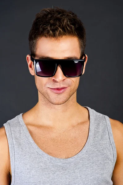 Handsome man in gray tanktop with smile and sunglasses Royalty Free Stock Photos