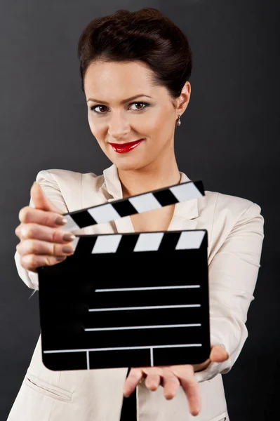 Женщина с фильмом хлопает на черном фоне — стоковое фото