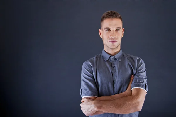 Man in blauw shirt op zwarte achtergrond — Stockfoto