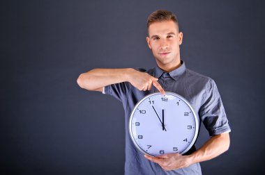 duvar saati koyu arka plan üzerinde tutan adam