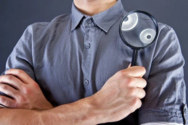 Man with magnifier on dark background — Stock Photo, Image