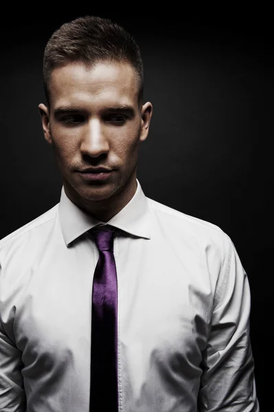 白いシャツと黒の背景にネクタイを持つ男 — ストック写真