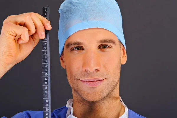Surgeon with centimeter over dark background — Stock Photo, Image