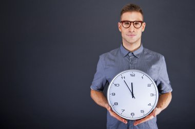 duvar saati koyu arka plan üzerinde tutan adam