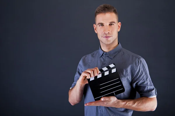 Uomo con film applauso su sfondo scuro — Foto Stock