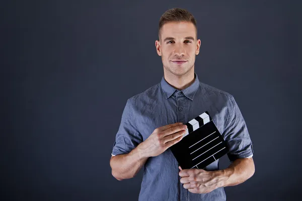 Uomo con film applauso su sfondo scuro — Foto Stock