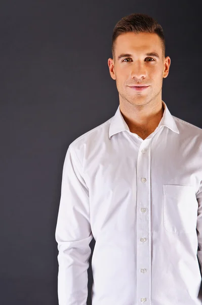 Mann mit weißem Hemd vor dunklem Hintergrund — Stockfoto