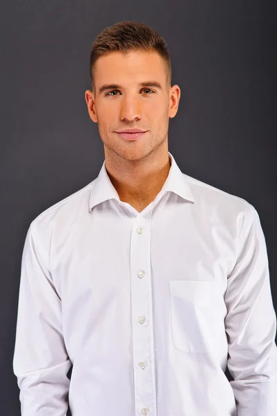 Hombre con camisa blanca sobre fondo oscuro — Foto de Stock