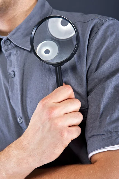 Man with magnifier on dark background — Stock Photo, Image