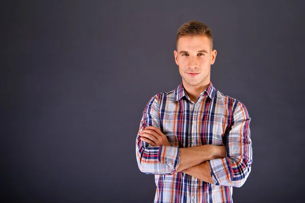 Man overdark achtergrond in gekwadrateerde shirt — Stockfoto