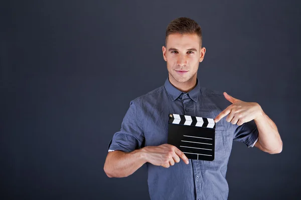 Homme avec film applaudir sur fond sombre — Photo