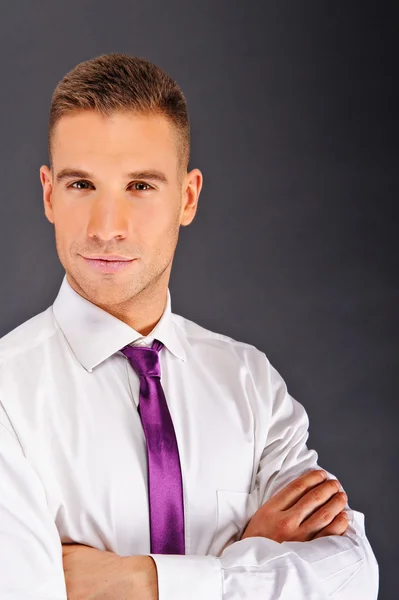 Man met paarse stropdas over donkere achtergrond — Stockfoto