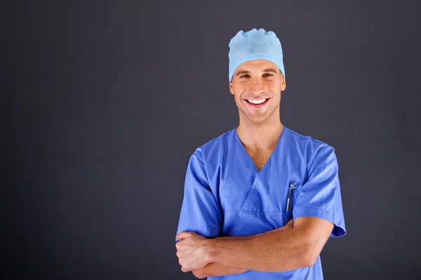 Chirurg mit erhobenem Daumen über dunklem Hintergrund — Stockfoto