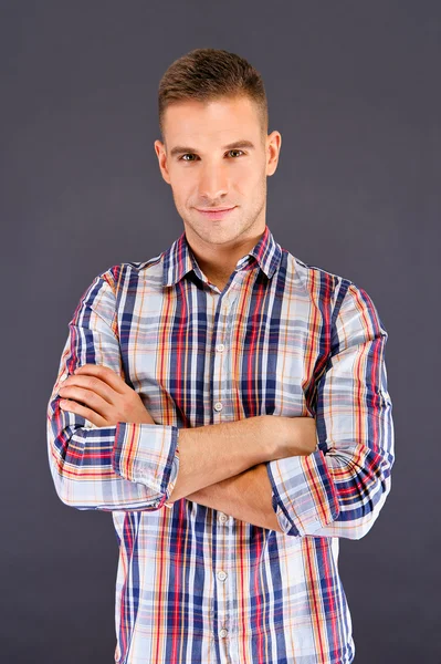 Man overdark achtergrond in gekwadrateerde shirt — Stockfoto