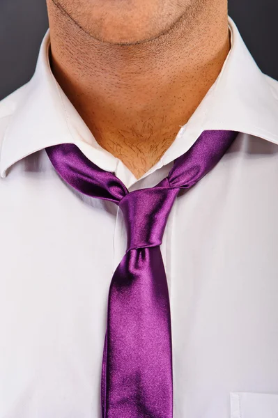 Człowiek z fioletowy krawat na ciemnym tle — Zdjęcie stockowe