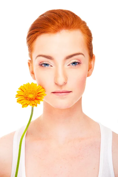 Mujer con flor naranja cerca de su cara sobre fondo blanco — Foto de Stock