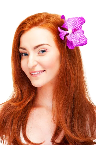 Woman with flower in her red hair — Stock Photo, Image