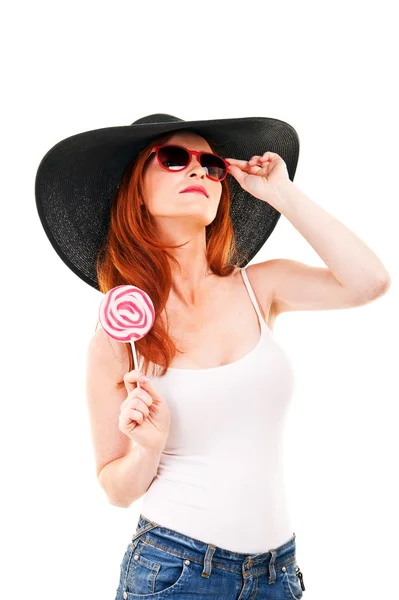 Girl with black hat holds lollipop. — Stock Photo, Image
