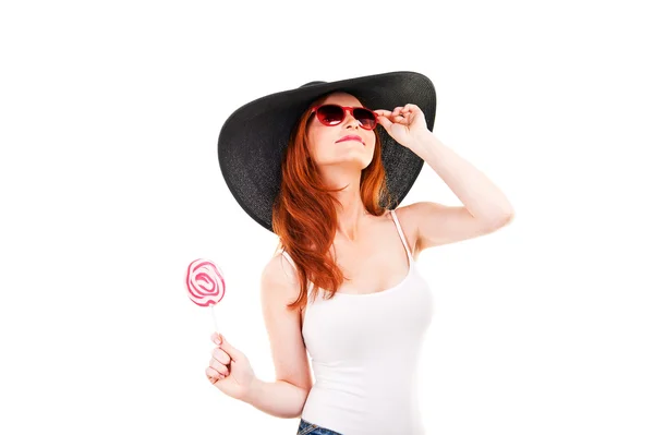 Mädchen mit schwarzem Hut hält Lutscher in der Hand. — Stockfoto