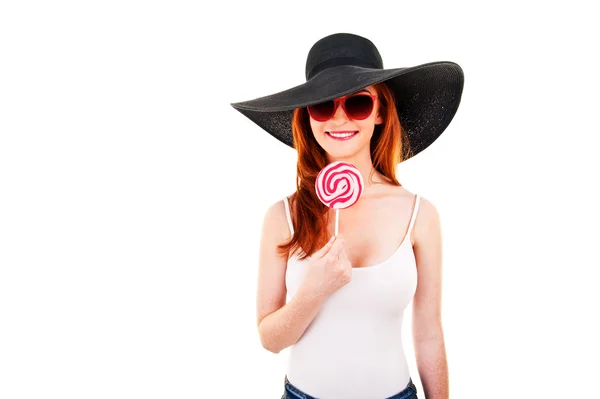 Girl with black hat holds lollipop. — Stock Photo, Image