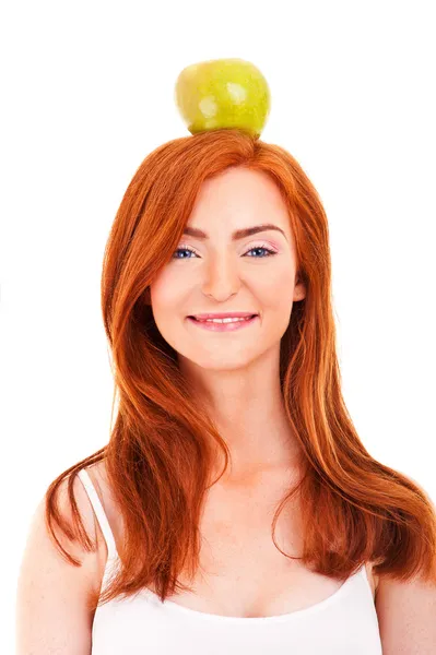 Рыжая женщина с зеленым яблоком на голове — стоковое фото