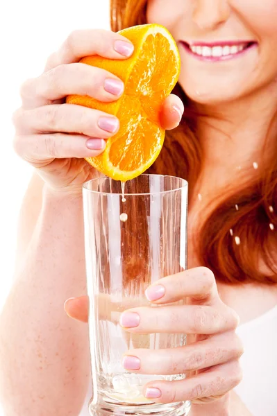 Vrouw die sinaasappelsap drinkt glimlachend met sinaasappels — Stockfoto