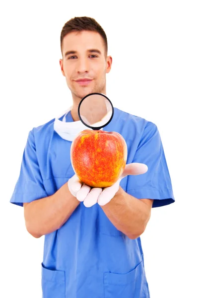 Doctor in blue apron holding red healthy apple — Stock Photo, Image