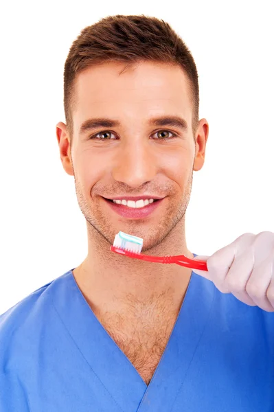 Un jeune homme se brossant les dents isolé sur fond blanc — Photo