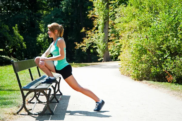 Giovane donna corridore stretching prima di correre — Foto Stock