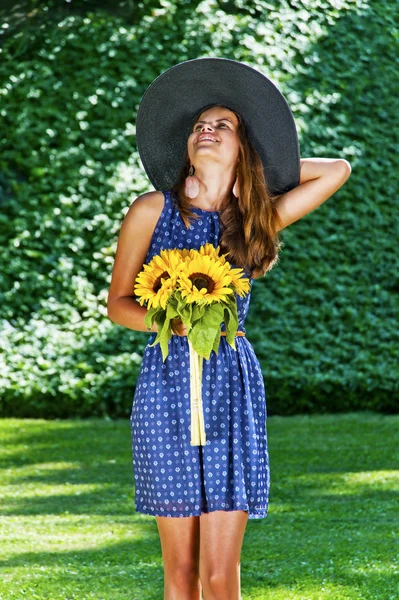 Беззаботная девушка счастлива в поле с цветами — стоковое фото