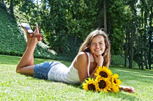 Bella Giovane Donna sdraiata nel prato dei fiori. Godetevi la natura — Foto Stock