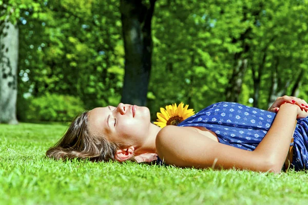 Jong meisje liggend op groen gras — Stockfoto