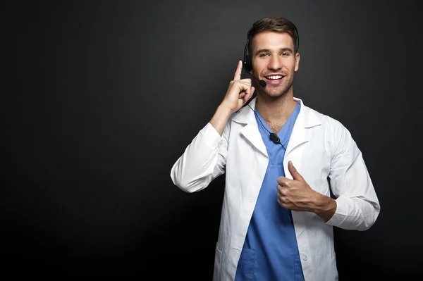 Portrait of a friendly doctor smiling giving thumbs up — Stock Photo, Image