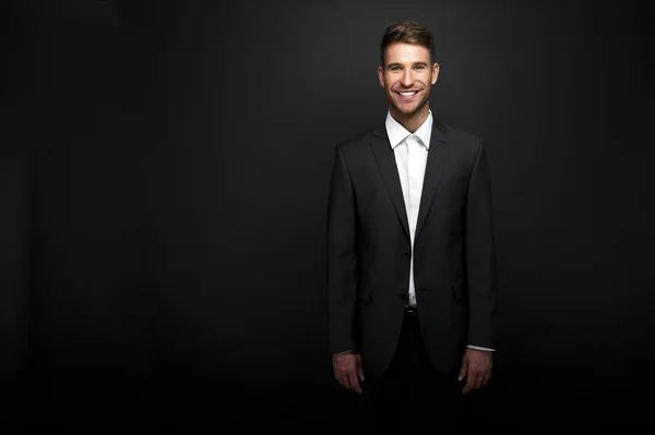 Бизнесмен стоит на темном градиентном фоне — стоковое фото
