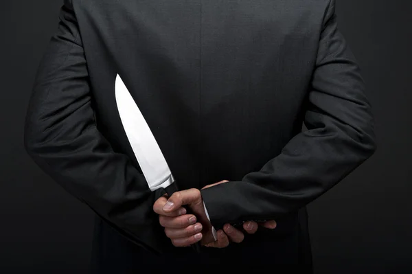 Businessman with knife behind his back — Stock Photo, Image