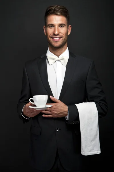 Young waiter in uniform serving hot coffee — Stock Photo, Image