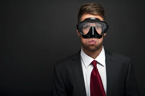 Businessman on a black background wearing a snorkel and mask — Stock Photo, Image