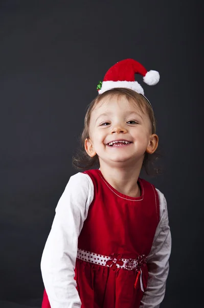 Noel Baba şapkalı kız gülümseyerek — Stok fotoğraf