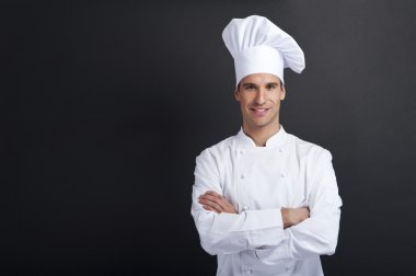 gülümseyerek kameraya gülümseyen koyu arka plan Cook