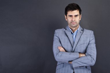 Gri arka planda duran havalı iş adamı