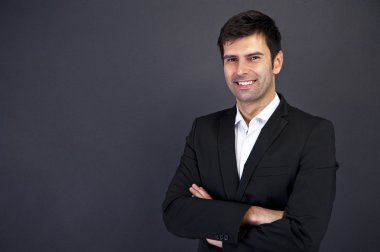 siyah elbiseli koyu arka plan üzerinde gülümseyen yakışıklı delikanlı