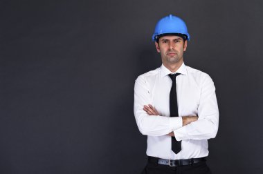 Young construction worker in hard hat on gray backgroundStock Ph clipart