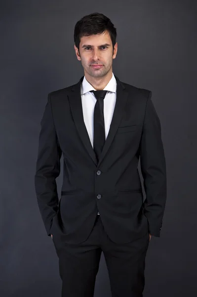 Businessman standing on grey background — Stock Photo, Image