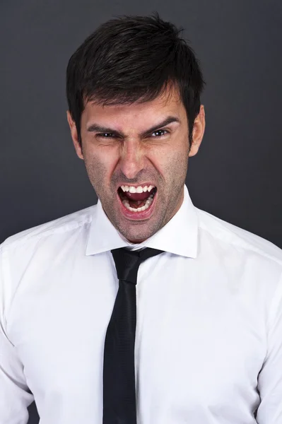 Hombre de negocios enojado sobre fondo oscuro — Foto de Stock