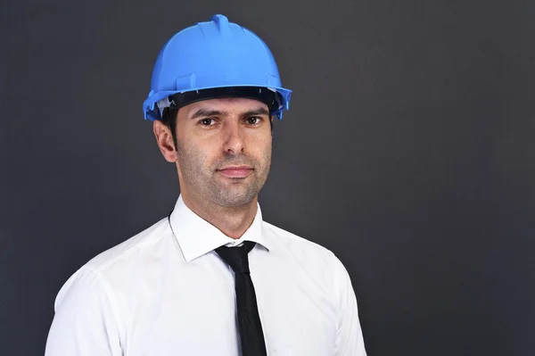 青年建筑工人在安全帽上的灰色背景 — 图库照片