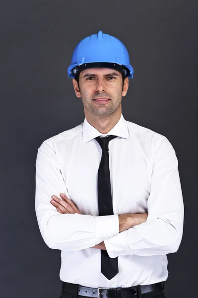 Young construction worker in hard hat on gray background — Stock Photo, Image