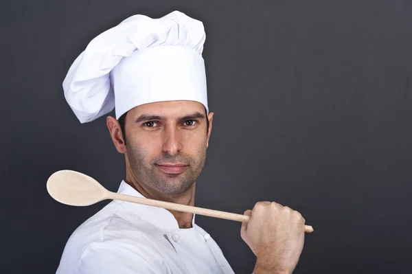 Portriat del cocinero con cuchara sobre fondo oscuro — Foto de Stock