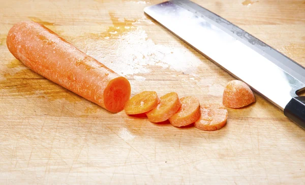 Mrkev a nůž na dřevěné prkénko — Stock fotografie